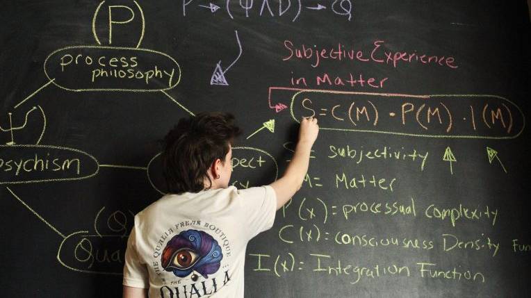 Student doing advanced calculations on a chalkboard.